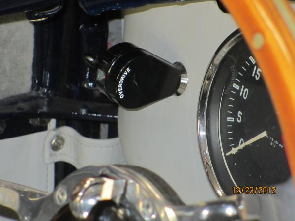 The black knob is the overdrive switch.  The steering wheel hum has an integrated turn signal....right in the hub with no lever.