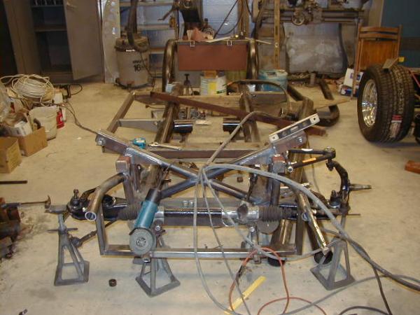 The chassis began as two lengths of 4" steel tubing on jack stands.  All parts were cut out by hand, assembled and hand welded to form the completed chassis.